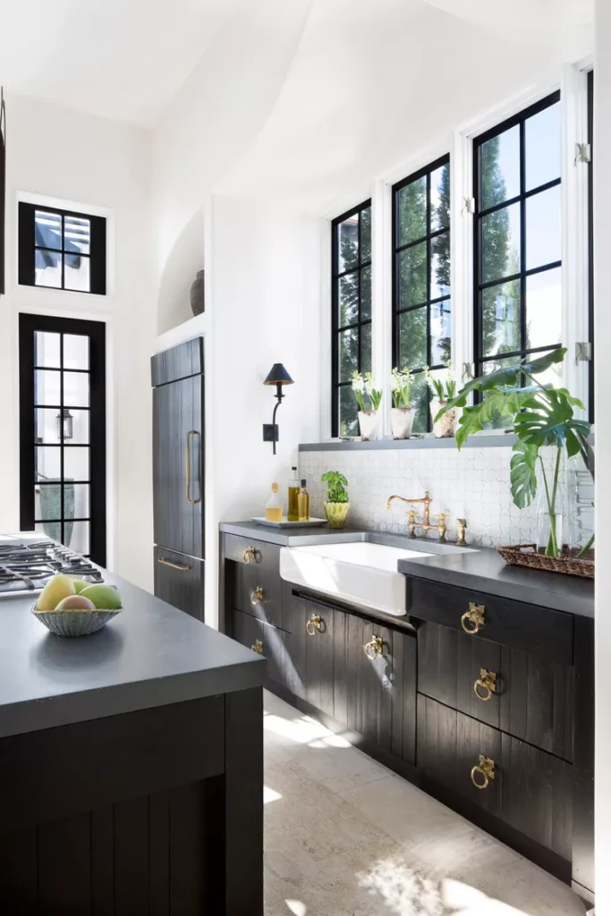 Black and white kitchen with fruits and plants displayed