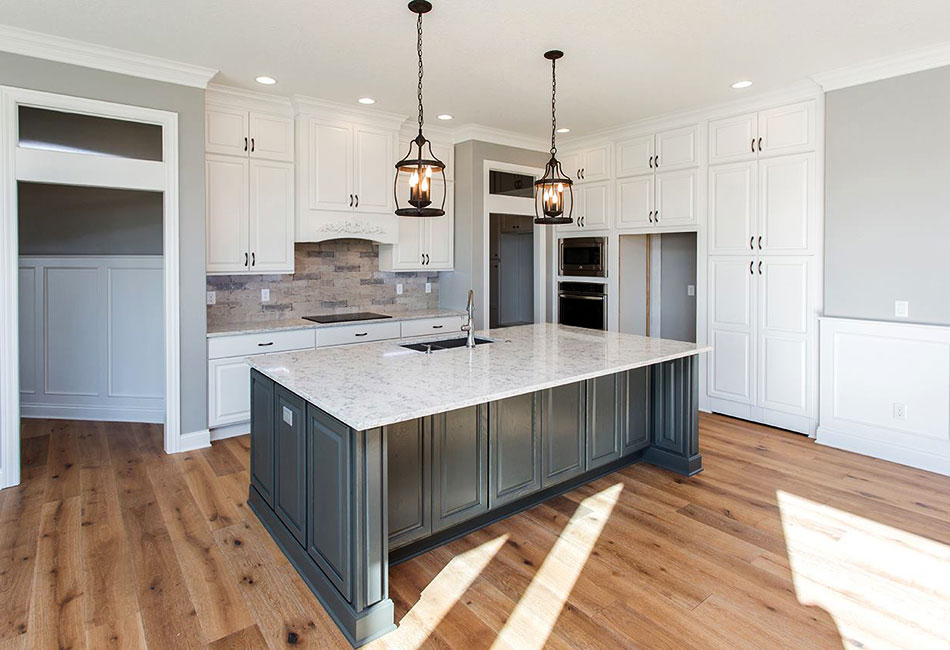 White and gray modern kitchen with sink build into island counter top